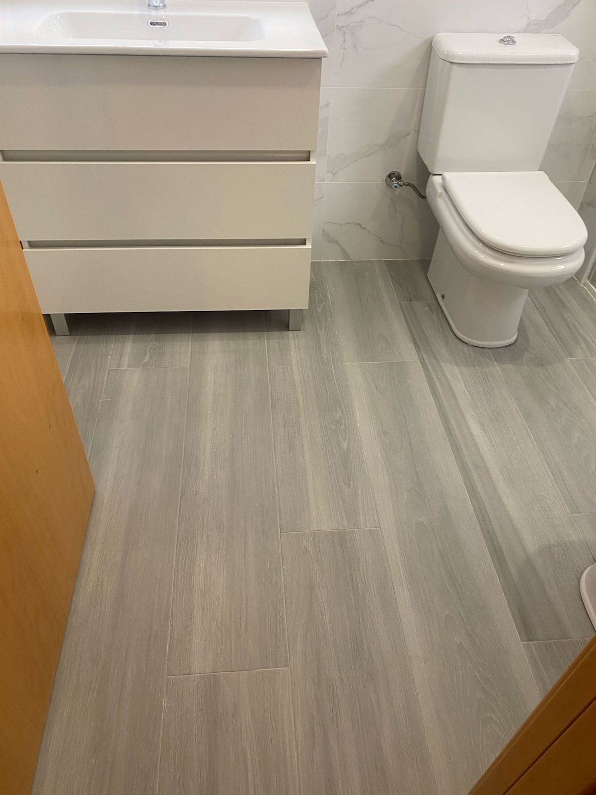 Reforma de baño con estilo minimalista y materiales de alta calidad, como cerámica y vidrio.